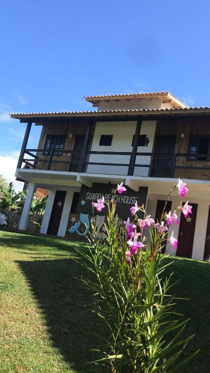 a building with pink flowers in front of it at Suites Guarda do Embau in Palhoça