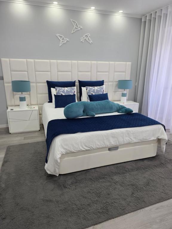 a bedroom with a large bed with blue pillows at My way in Azores in Horta