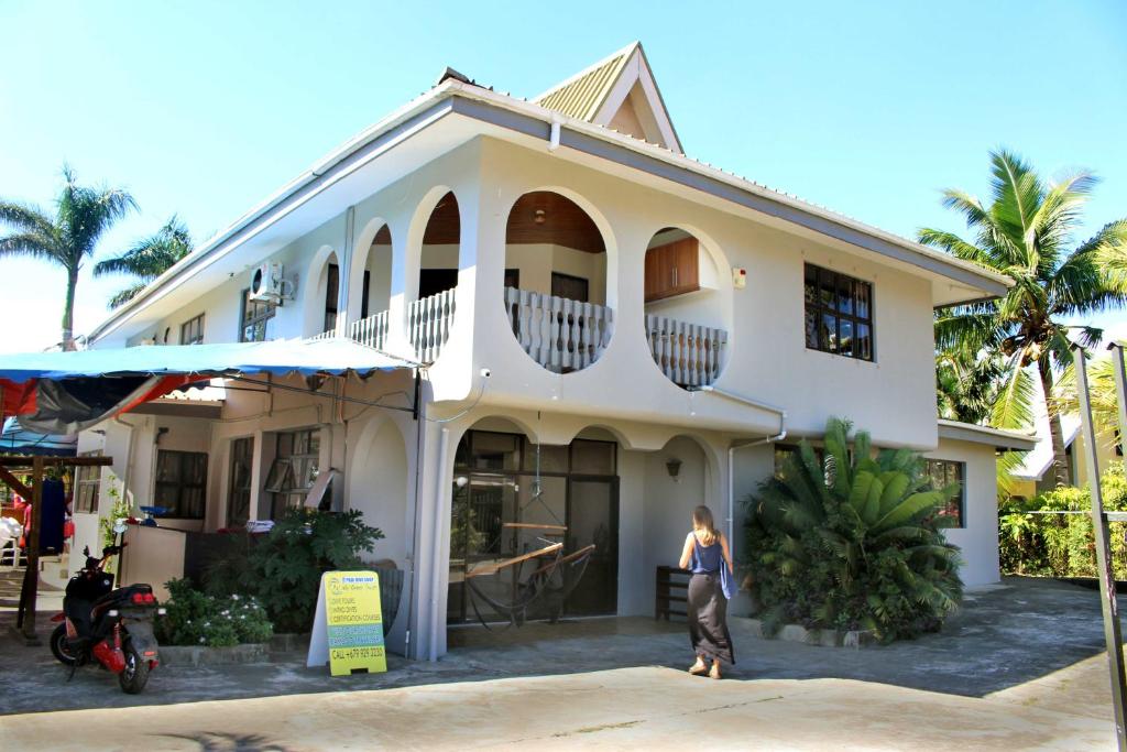 una mujer parada frente a una casa blanca en Bluewater Lodge, en Nadi