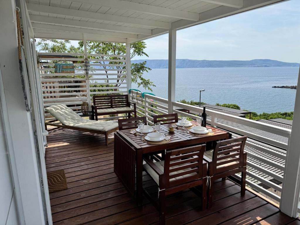 a table and chairs on a deck with a view of the water at Adriastay 360 in Klenovica