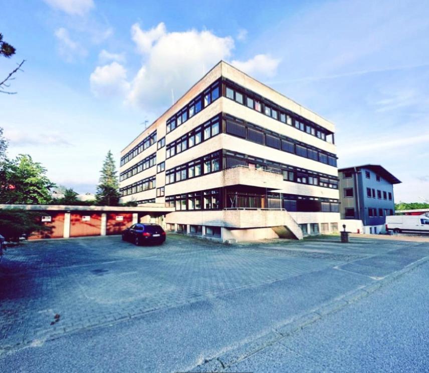 a large building with a car parked in a parking lot at Monteurunterkunft Schlierbach in Schlierbach