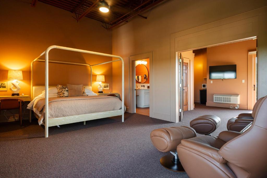 a bedroom with a canopy bed and a living room at Hotel Broad Ripple in Indianapolis