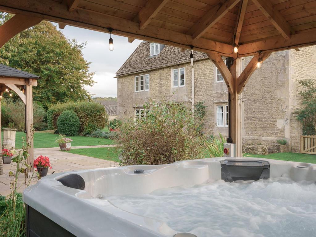 a bath tub in a yard with a house at Reybridge House in Chippenham