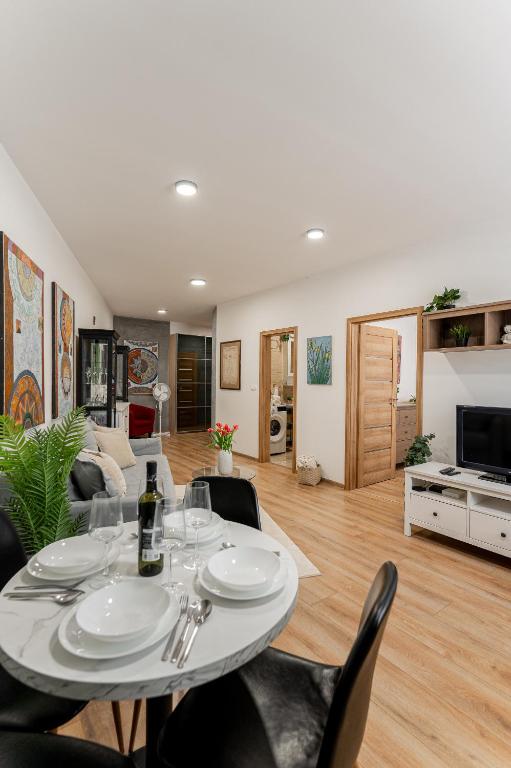 a dining table and chairs in a living room at Centrum Kosice Apartment 60m2 4 beds in Košice