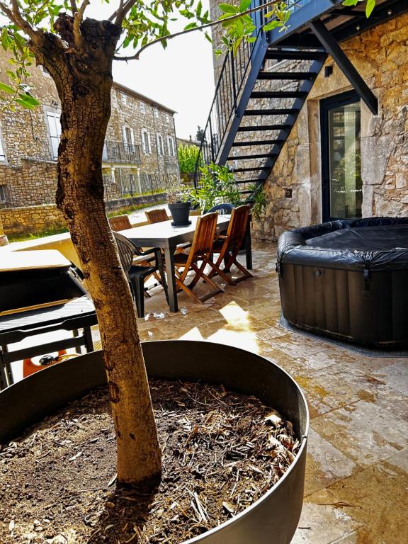 a tree in a large planter with a table and chairs at La Terrette in Vagnas