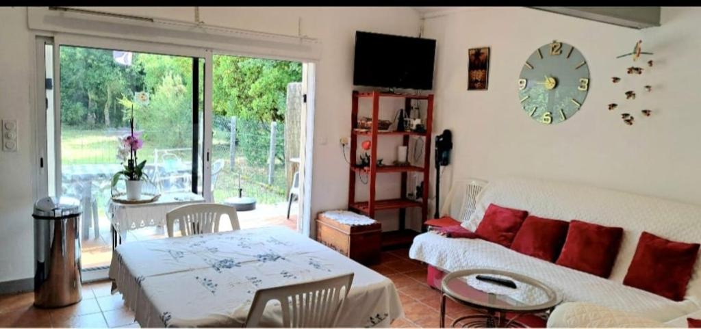a living room with a couch and a table at Ptit Piment petite maison avec terrasse in Lanton
