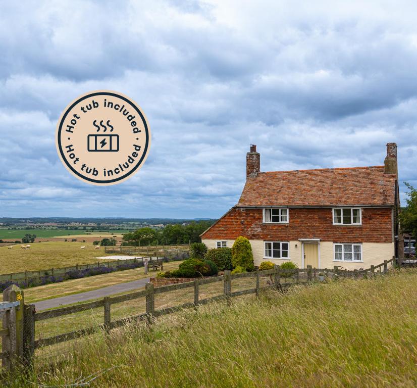 a building with a sign in front of a house at Coldharbour Cottage with Hot Tub in Stone