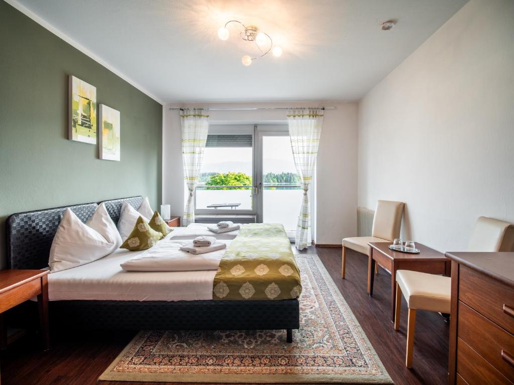 a bedroom with a bed and a living room at Faaker See Inn by Aurora in Faak am See