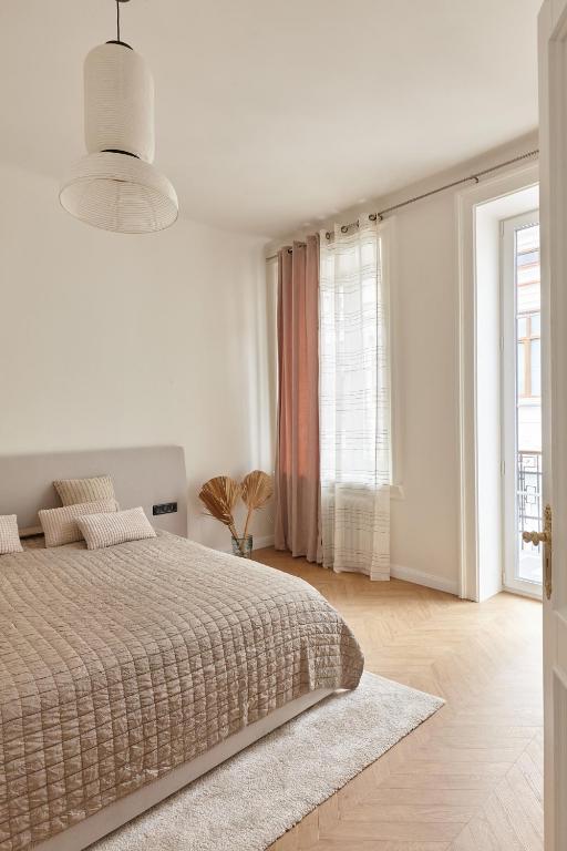 a white bedroom with a bed and a large window at Karma Rooms in Ternopil