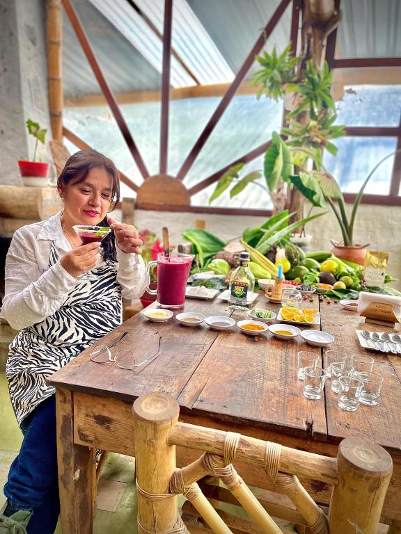 a woman sitting at a wooden table eating food at Hotel Casa Tarzan San Agustin in San Agustín