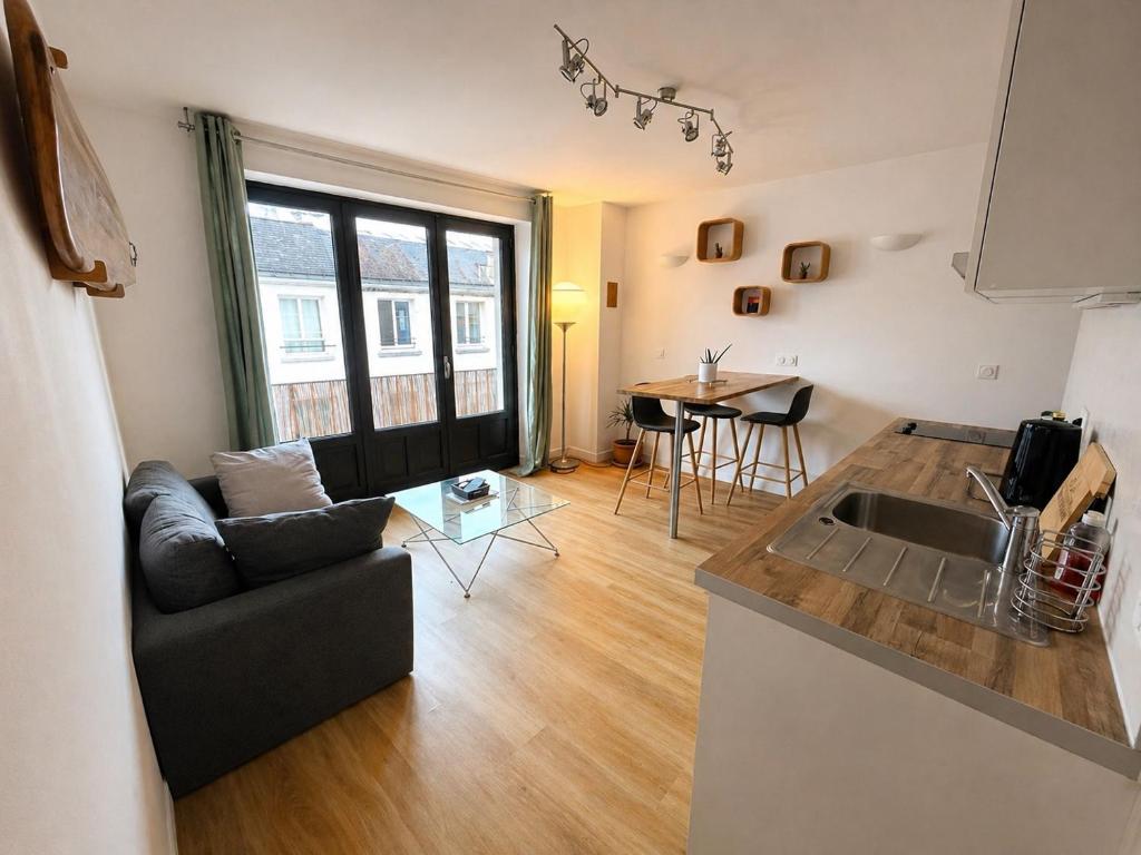 a kitchen and living room with a couch and a table at Éclat d'Écume - Vue mer - Hypercentre - 31 M2 - Quiberon in Quiberon