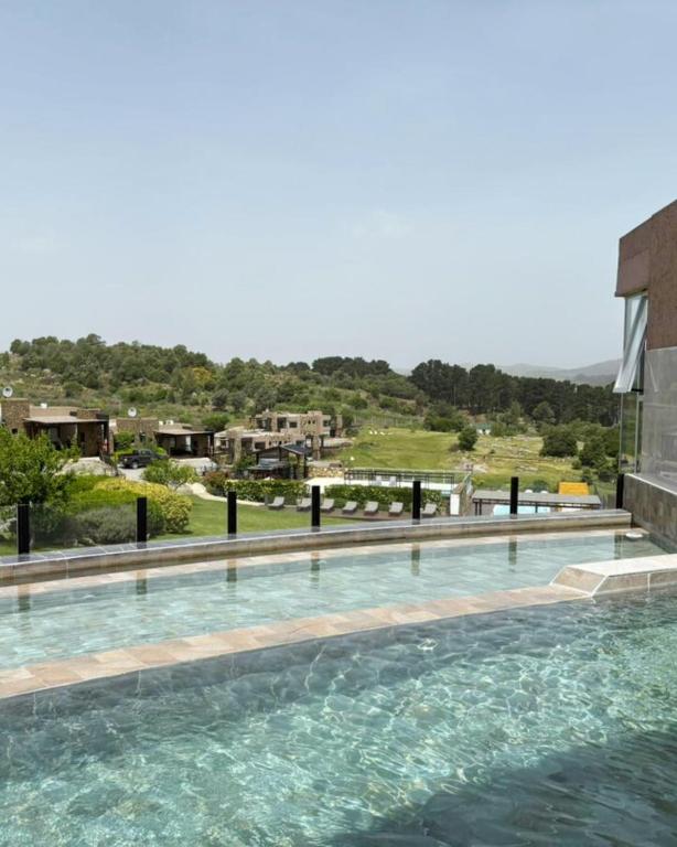 ein Schwimmbecken mit blauem Wasser vor einem Gebäude in der Unterkunft Posta Natural in Tandil