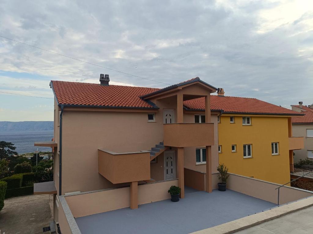 a house with a balcony on the side of it at Cozy apartments with sea view in Novi Vinodolski