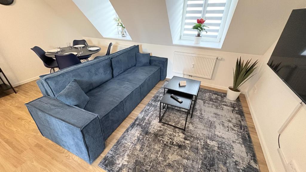 a living room with a blue couch and a table at 247 Reside - Apartment SZ3 in Straubing