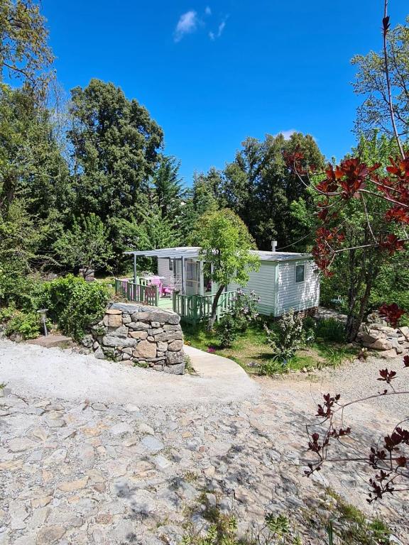 a cottage with a stone wall and a stone path to it at Chalet de la Source in Casanova