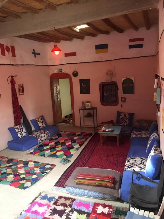 a room with couches and pillows in a house at Merzouga Hostel in Merzouga