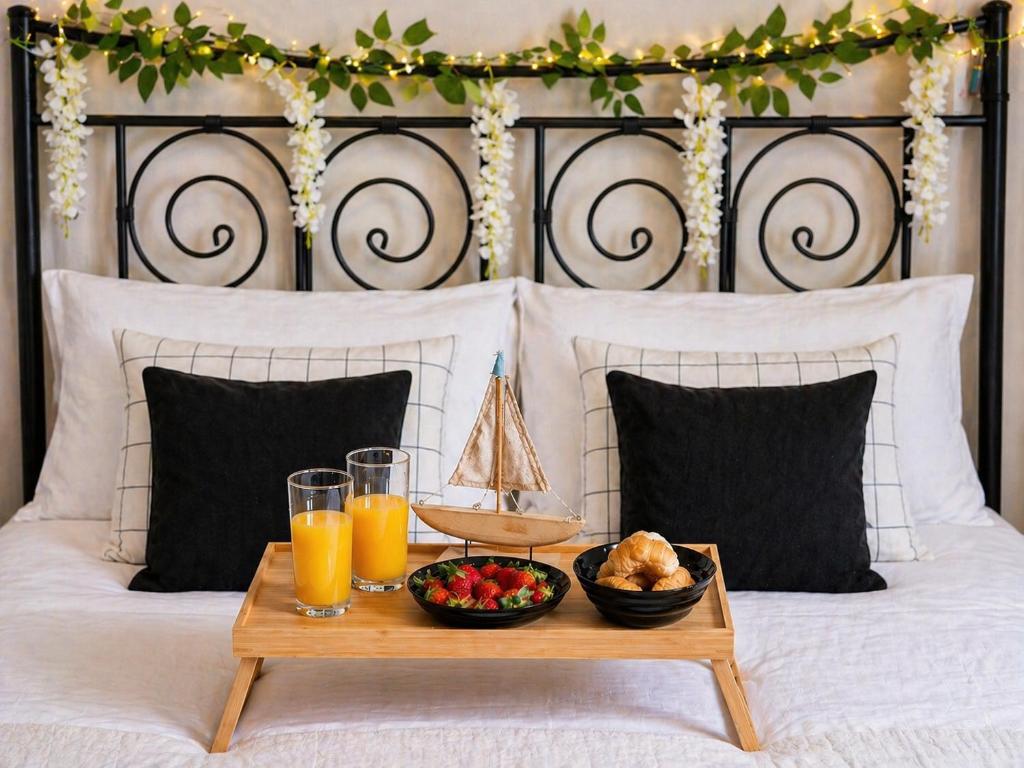 a bed with a tray of food and drinks on it at Cocomelo apts 3 luxury in Heraklio