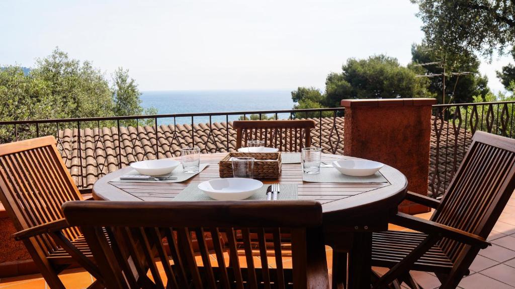 a wooden table with bowls on top of a balcony at Residenza Madea - Vista Mare, Piscina, Spiaggia Privata e Parcheggio in Marina di Andora