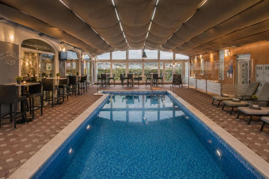 a pool in a hotel with tables and chairs at Apartments Peris Resort in Novalja