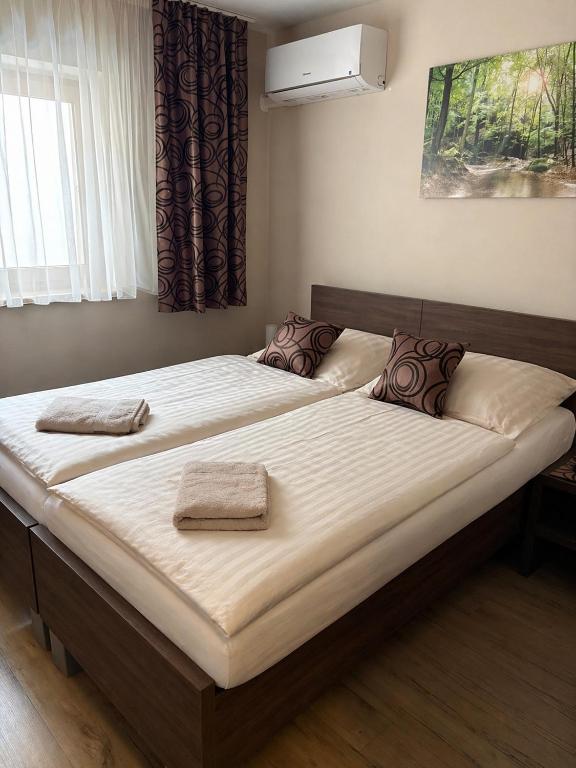 a large bed with two towels on top of it at Pikolo - izby na prenájom in Nové Mesto nad Váhom