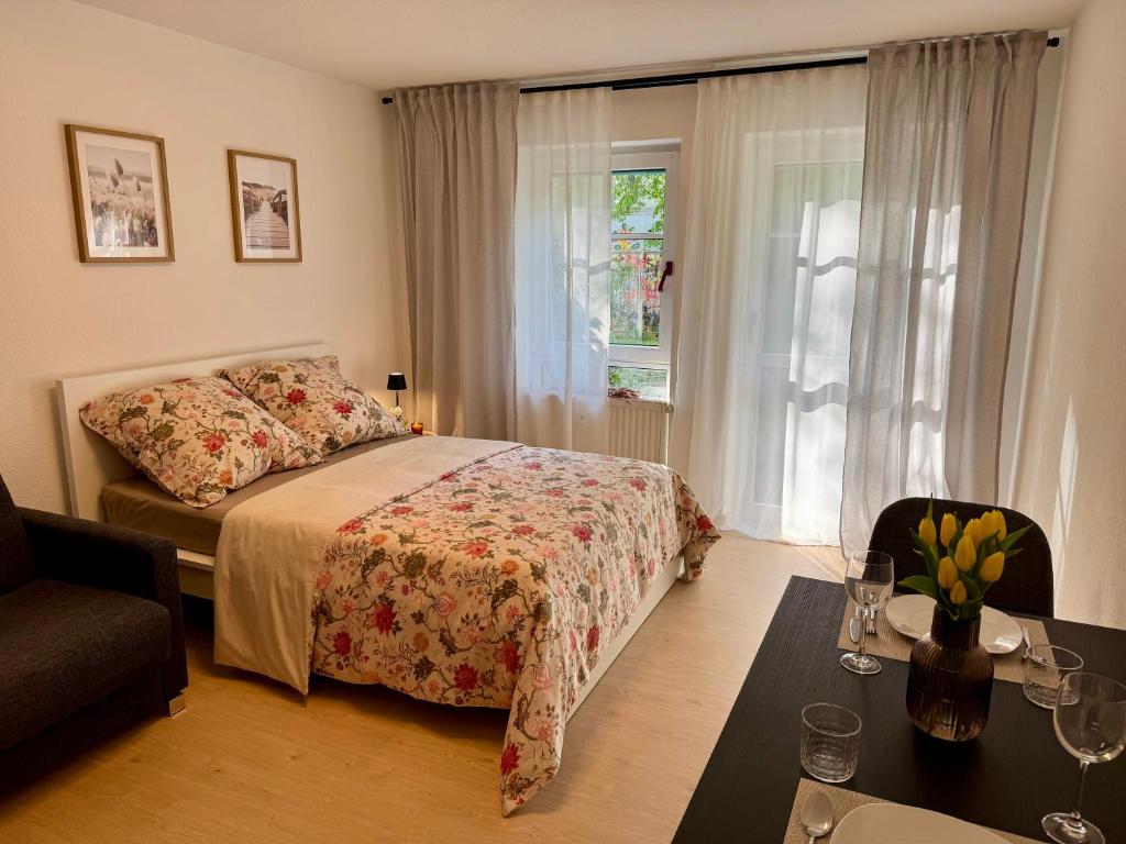 a bedroom with a bed and a table and a window at Little Dream Konstanz in Konstanz