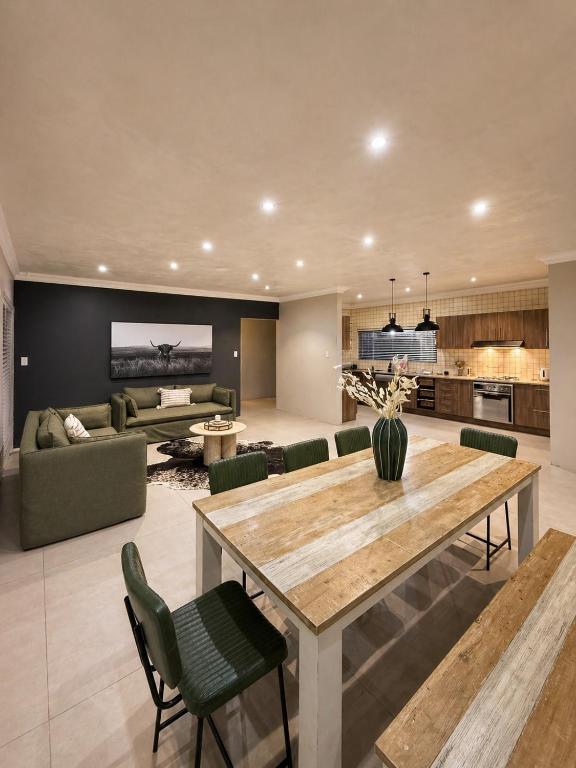 a kitchen and living room with a table and a couch at Lenmed Prime Spot in Kimberley
