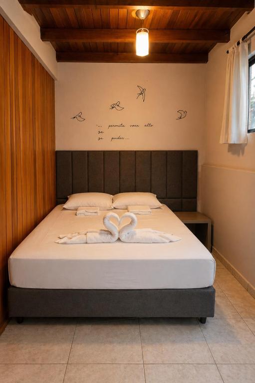 a bedroom with a bed with two white towels at Refúgio com Varanda, Wi-Fi Rápido, 450m da Praia, seu Cantinho em BC in Balneário Camboriú