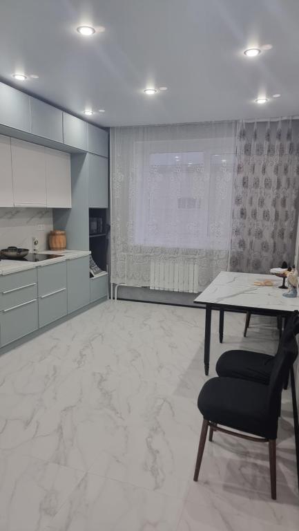 a large kitchen with a table and a chair at Luxury in Kokshetau