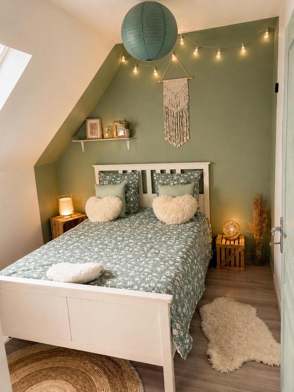 a bedroom with a bed with pillows on it at Côte d'Opale - Maison Cocooning Classé 3 Étoiles in Marquise