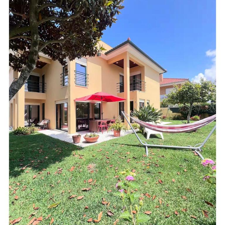 a hammock in a yard in front of a house at Casa SAL in Esposende