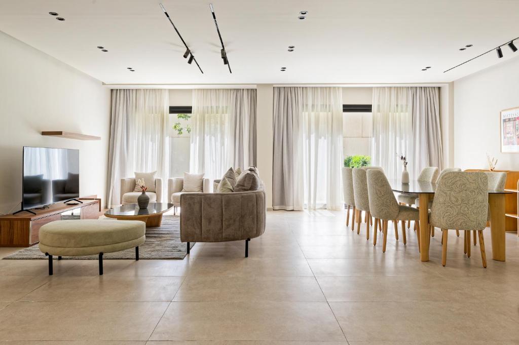 a living room with a table and chairs at VESTA - Maison Zayed City in Sheikh Zayed