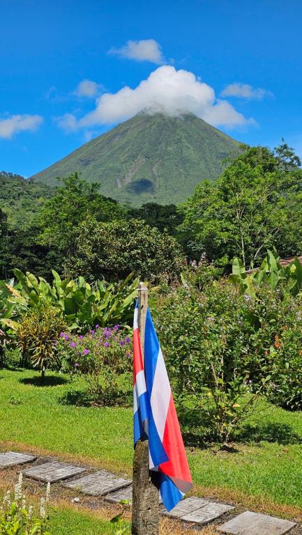 a flag hanging on a rock with a mountain in the background at Flora Glamping de Abuela in Fortuna