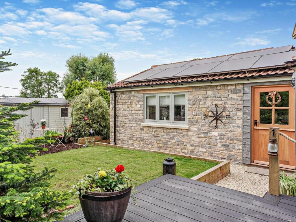 a garden with a brick house with a wooden deck at 1 Bed in Shepton Mallet oc-94296 in Pilton