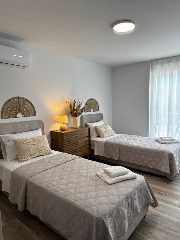 a bedroom with two beds and a table with a lamp at Oleana Cosy Studio in Lampi