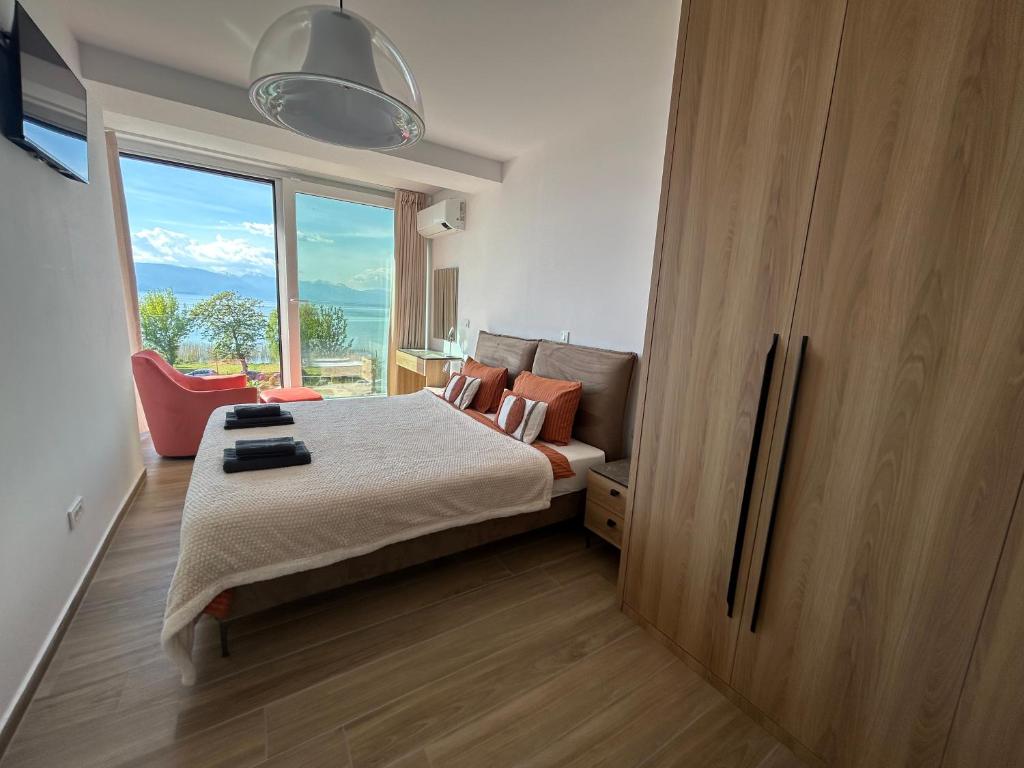 a bedroom with a bed and a large window at SANI Apartments by Kanevce in Ohrid