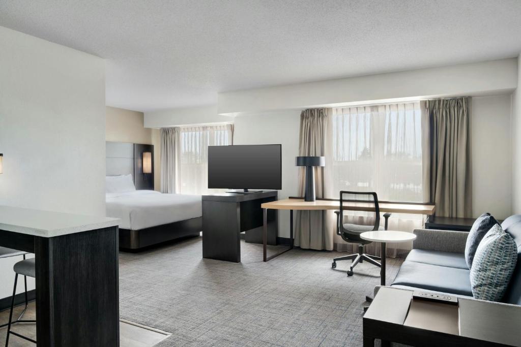 a hotel room with a bed and a television at Residence Inn Merrillville in Merrillville