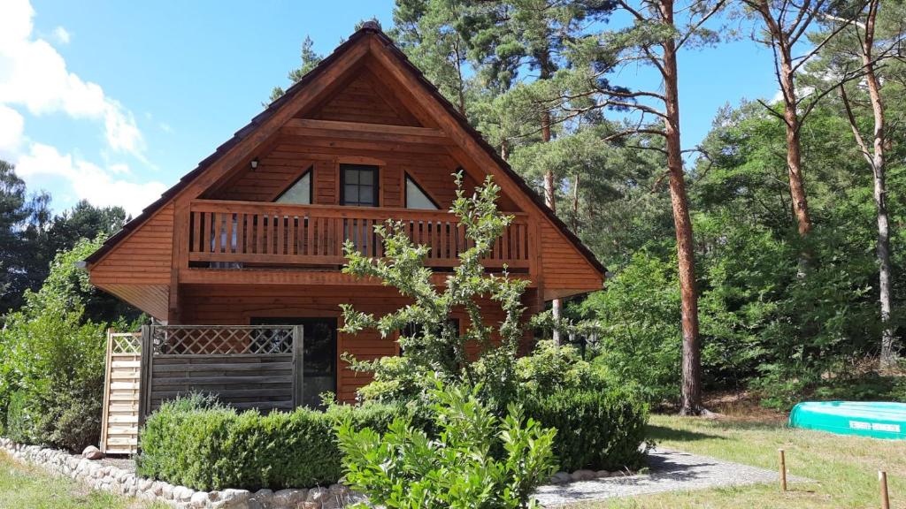 a log cabin in the woods with a porch at Ferienhaus Milan mit Ruderboot - 300 m vom Fleesensee in Silz