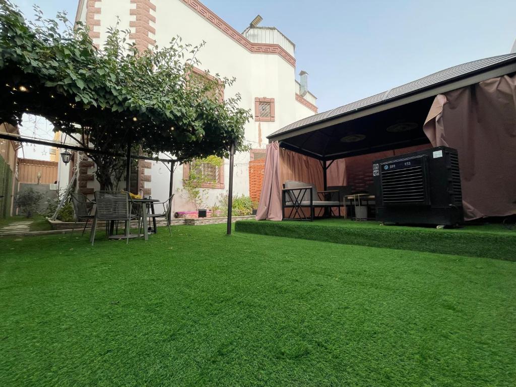 a lawn with a tent and a table on it at دار ناصر in Riyadh