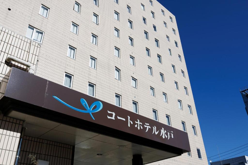 a building with a sign in front of it at Court Hotel Mito in Mito