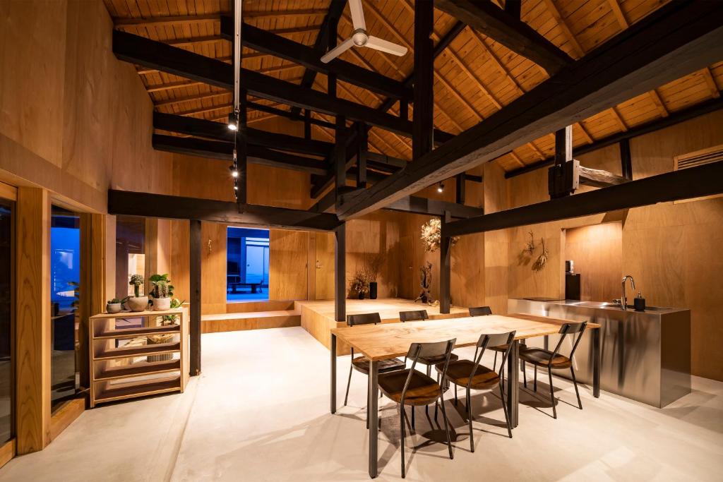 a kitchen with a wooden table and chairs at 古民家一棟貸し 加持ノ宿 高知県幡多郡黒潮町 in Kuroshio