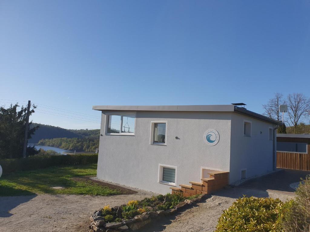 a small white house with a staircase on it at Ferienhaus am Thüringer Meer in Bad Lobenstein