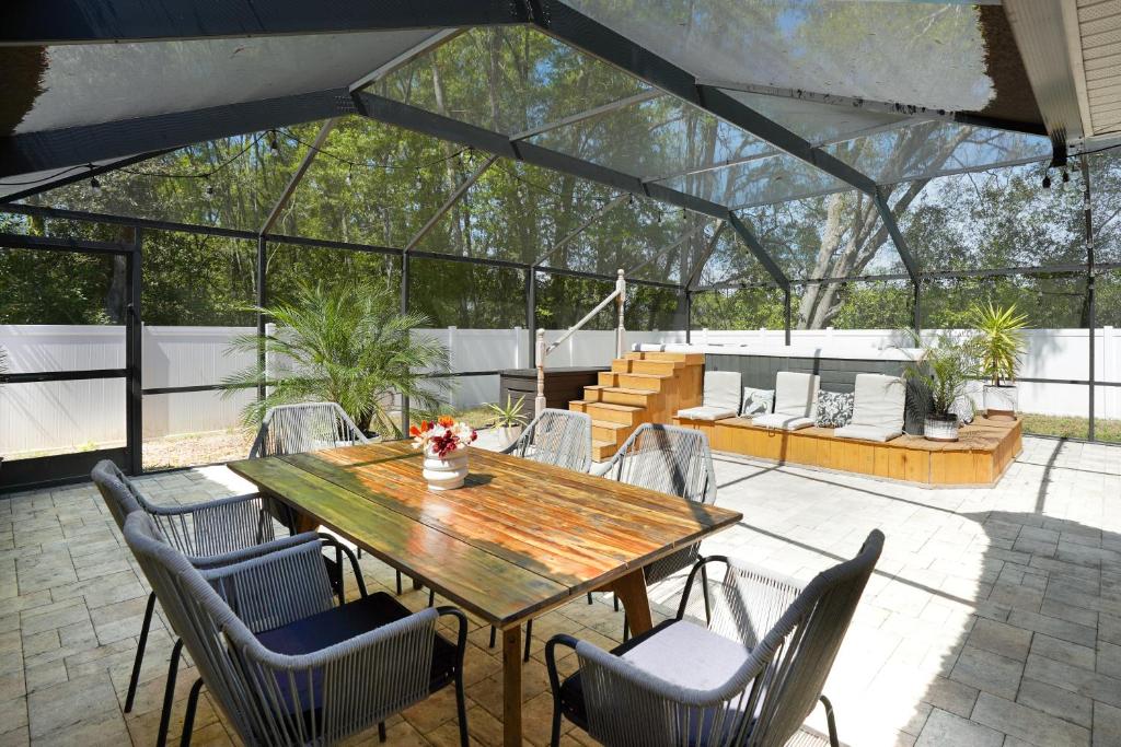 a patio with a wooden table and chairs at Villa Summerfield Swim Spa in Summerfield