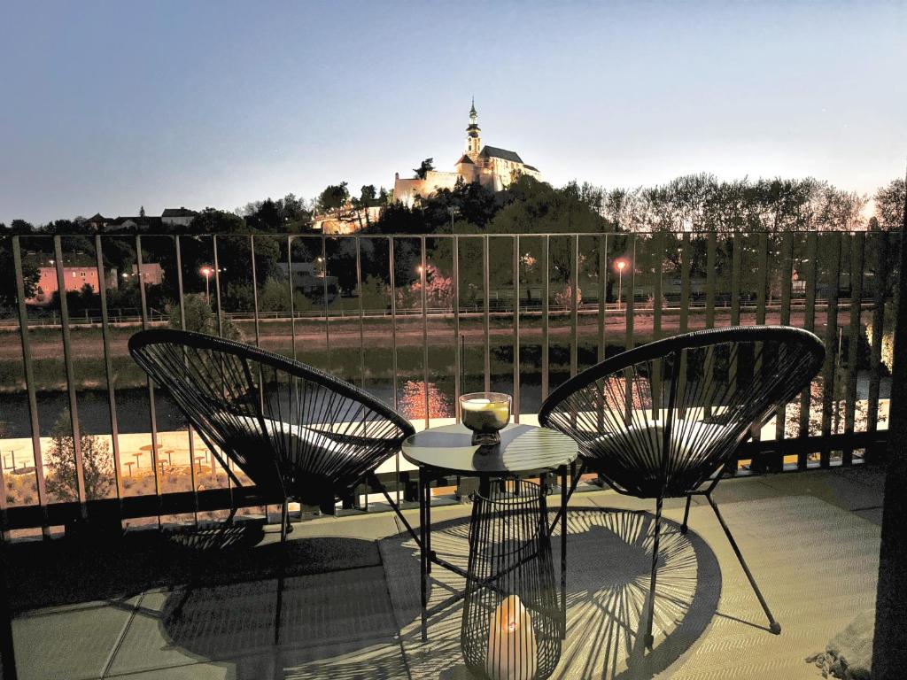a table and chairs on a balcony with a view of a building at PROMENADA Apartments with FREE PARKING in Nitra