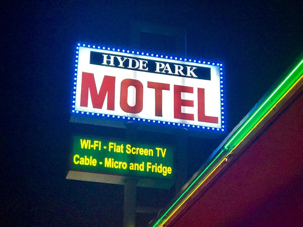 una señal para un hotel con una señal de neón en Hyde Park Motel, en Los Ángeles