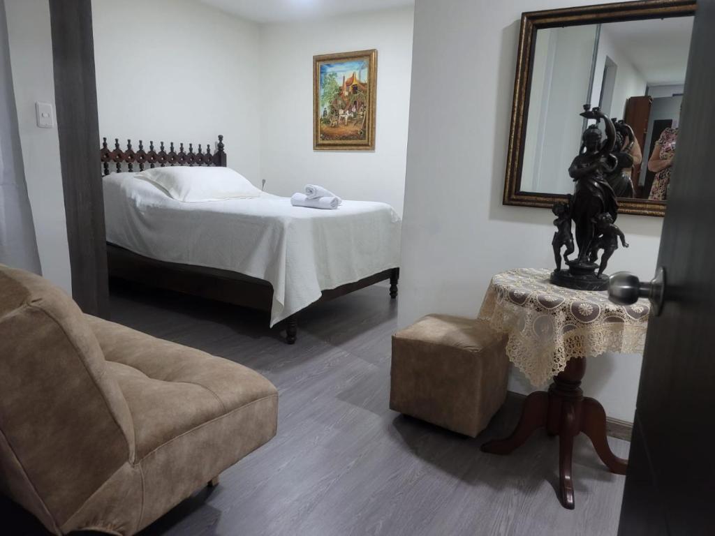 a bedroom with a bed and a chair and a mirror at BED & Breakfast in Bogotá
