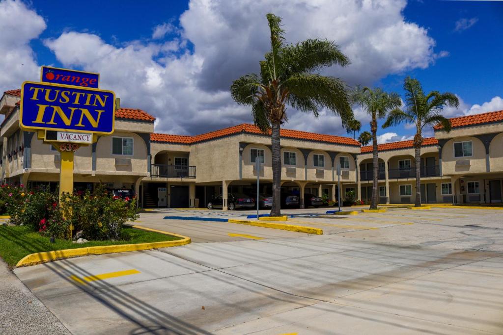 a tiki inn with a sign in a parking lot at Orange Tustin Inn in Orange in Orange