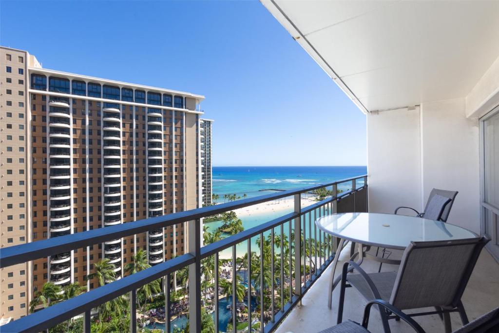 a balcony with a table and chairs and the ocean at Ilikai Tower 1538 condo in Honolulu