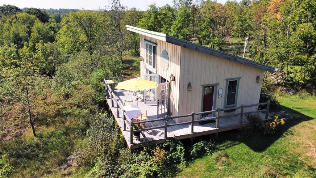 a small house with a porch and an umbrella at Longview Spectacular Forest Views on 88 Acres in Westport