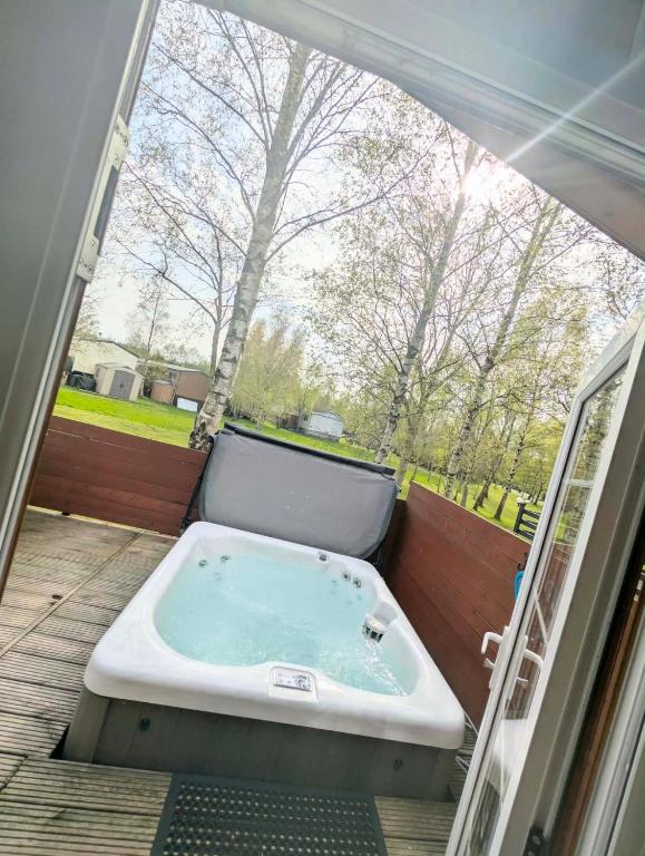 a bath tub sitting on a patio with a window at J&J Retreat in Morpeth