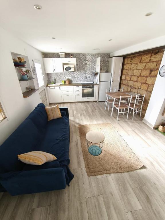 a living room with a blue couch and a kitchen at Beach house in Rincón de la Victoria